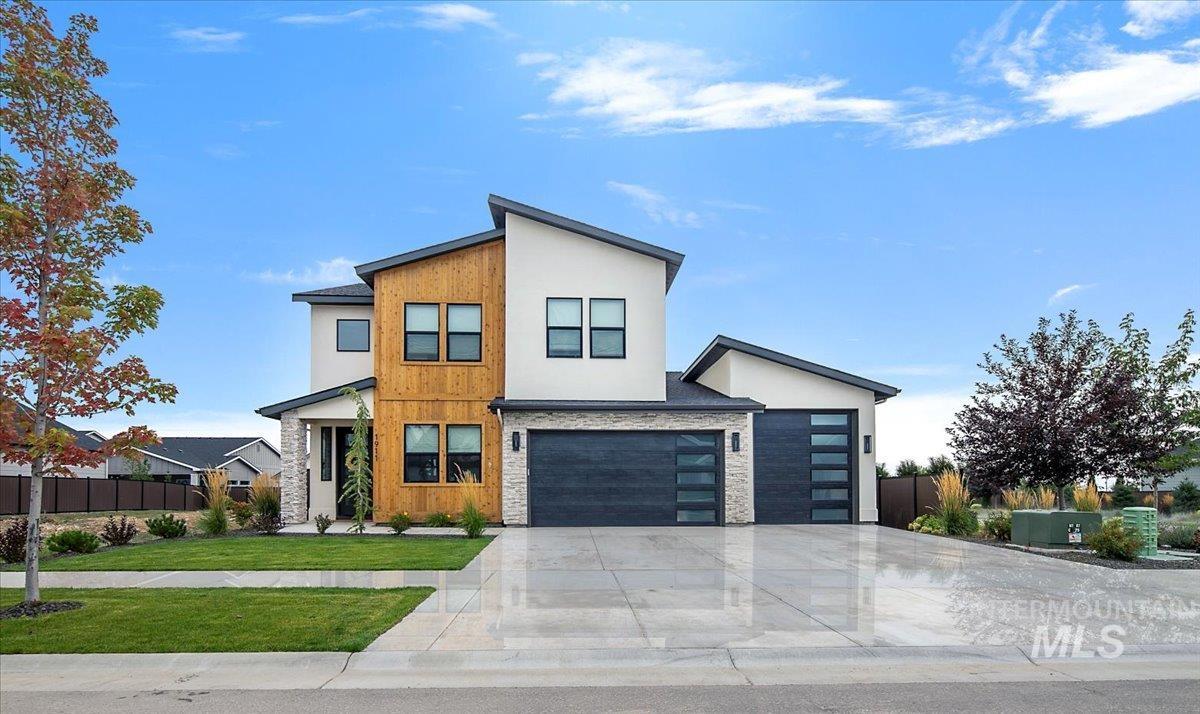 Contemporary home featuring stone siding, concrete driveway, and stucco siding
