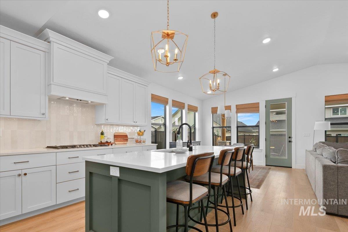 1911 East Mainacht Street Meridian, ID 83642 - Photo 49 of 49 Kitchen with green cabinetry, white cabinets, light wood finished floors, open floor plan, and an island with sink