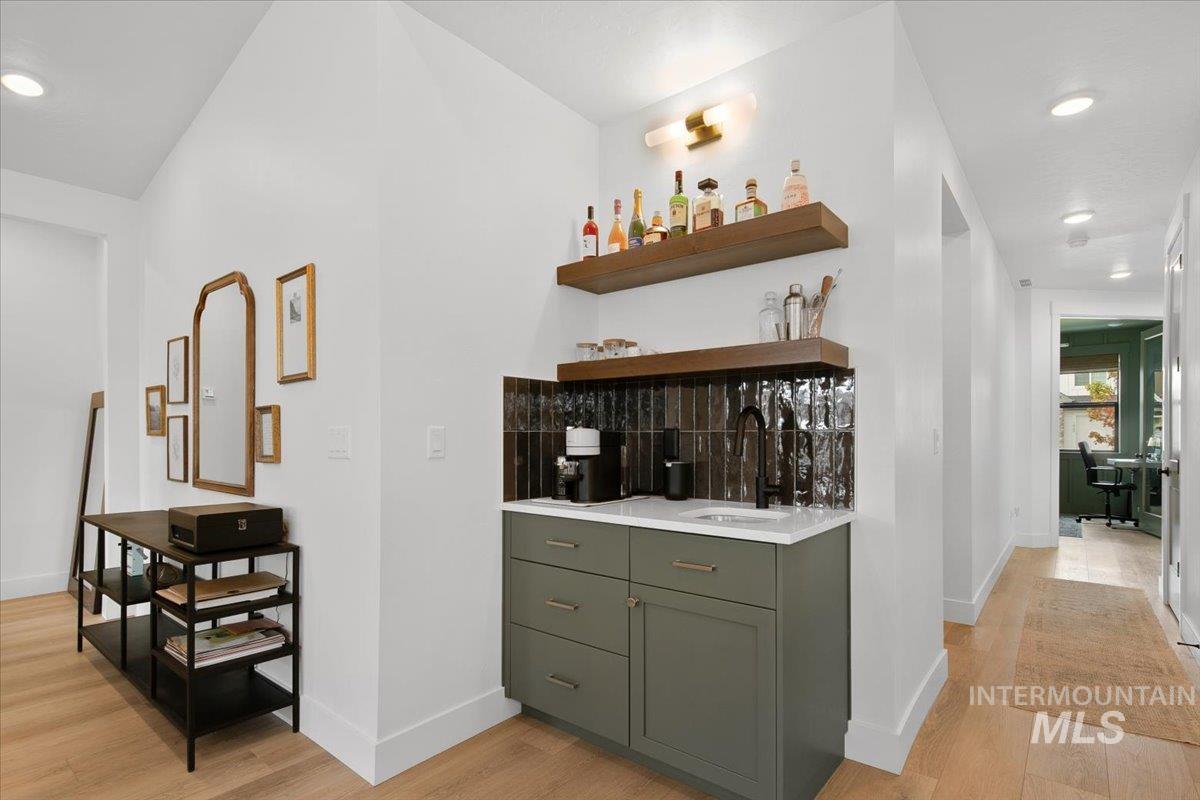 1911 East Mainacht Street Meridian, ID 83642 - Photo 18 of 49 Indoor wet bar with recessed lighting, light wood-style floors, open shelves, light stone counters, and green cabinets