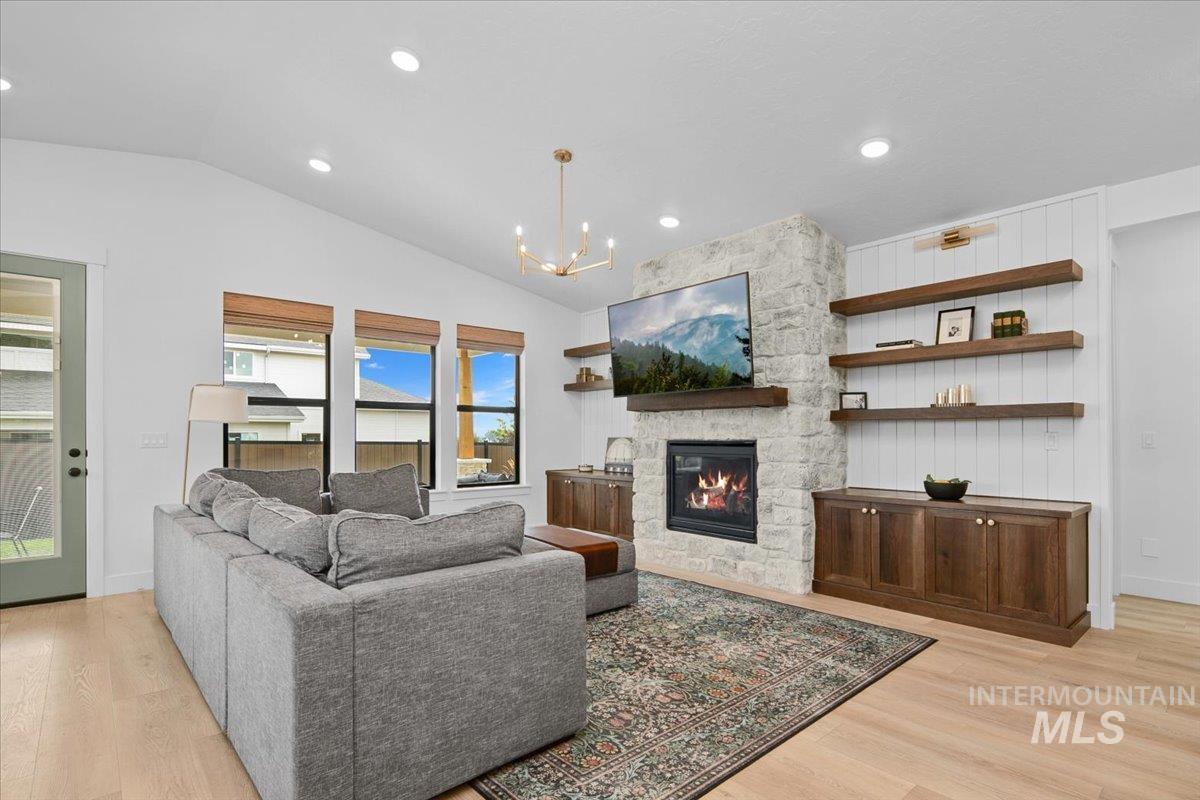 1911 East Mainacht Street Meridian, ID 83642 - Photo 20 of 49 Living room with light wood-style flooring, a fireplace, a chandelier, recessed lighting, and vaulted ceiling