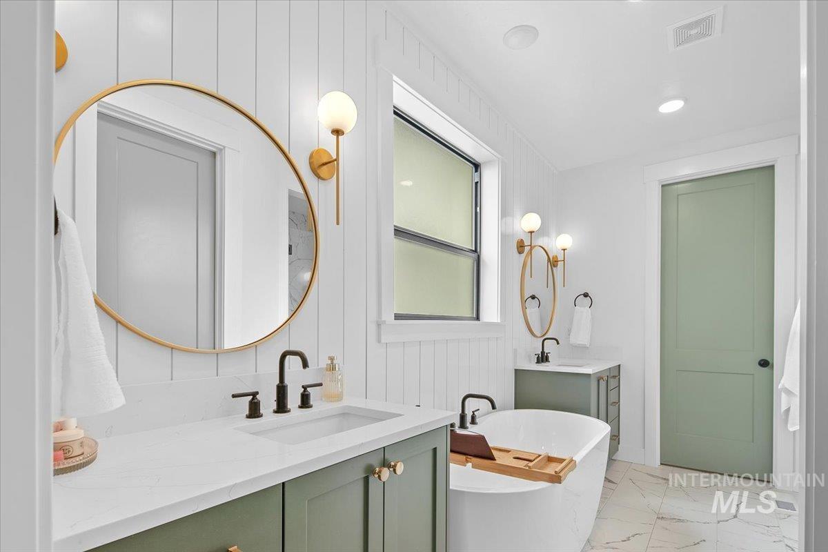 1911 East Mainacht Street Meridian, ID 83642 - Photo 27 of 49 Full bath with two vanities, light marble finish flooring, a freestanding bath, recessed lighting, and wooden walls