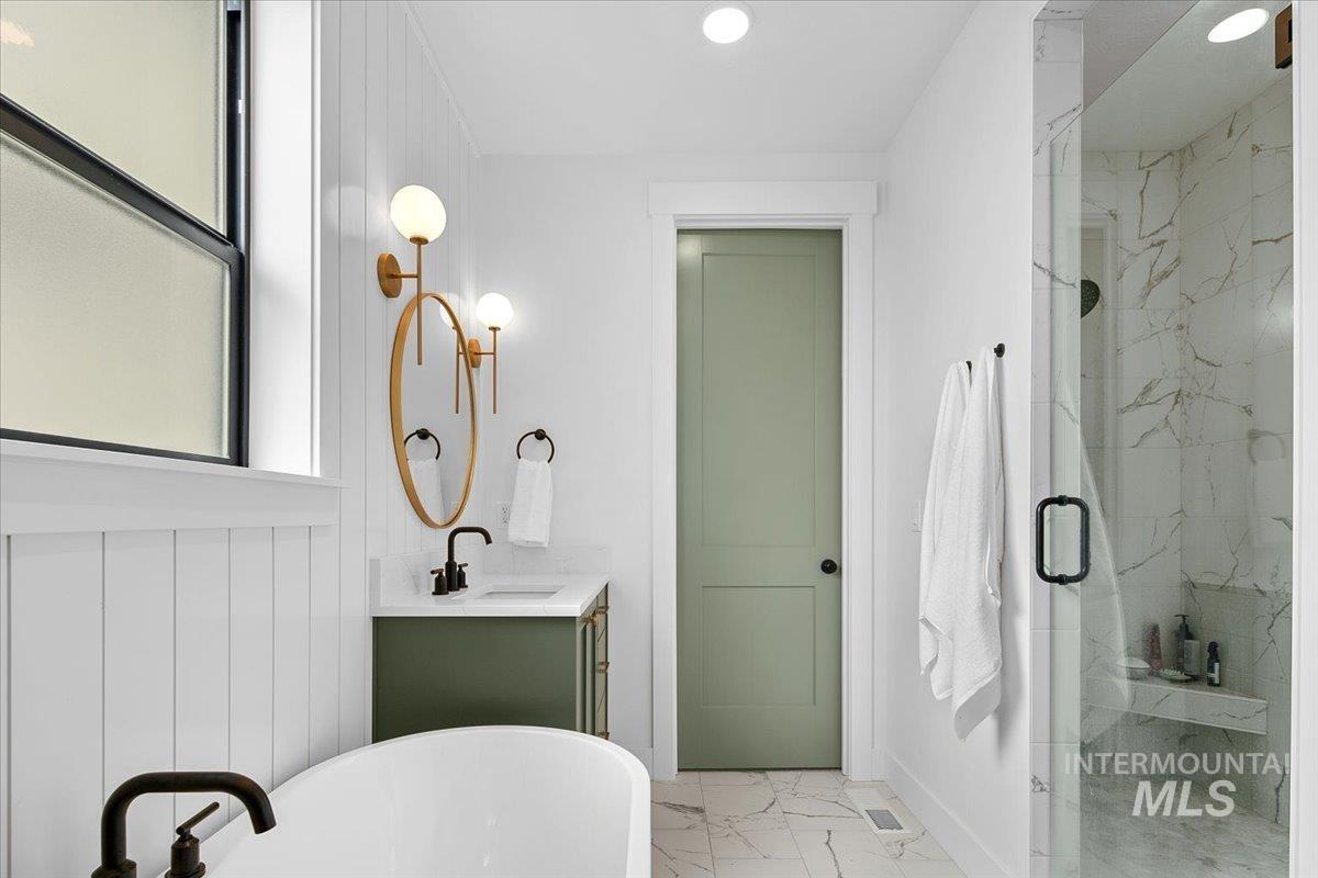 1911 East Mainacht Street Meridian, ID 83642 - Photo 28 of 49 Bathroom with vanity, a freestanding tub, a marble finish shower, light marble finish floors, and plenty of natural light