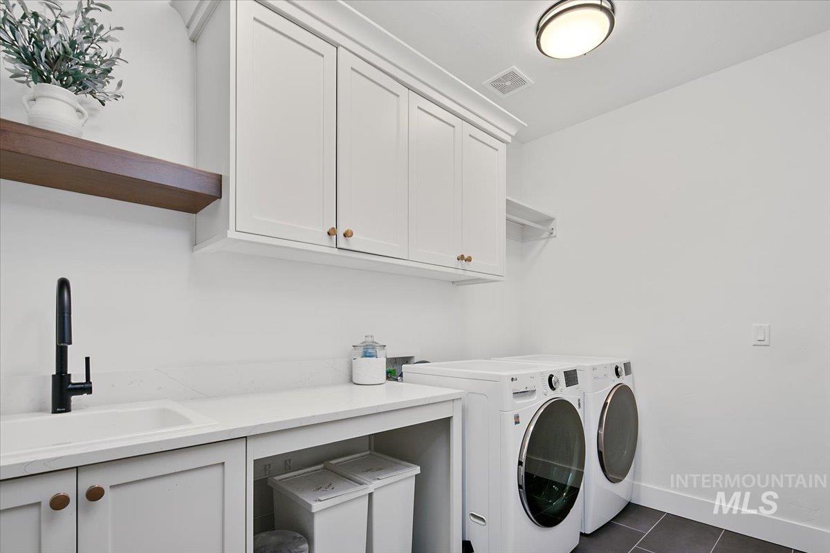 1911 East Mainacht Street Meridian, ID 83642 - Photo 31 of 49 Laundry room with dark tile patterned flooring, independent washer and dryer, and cabinet space