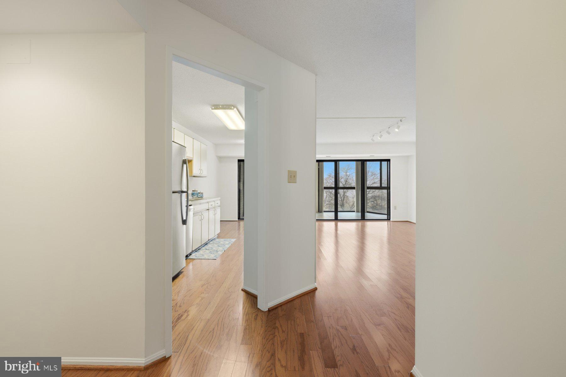 15107 Interlachen Drive, Unit 2801 Silver Spring, MD 20906 - Photo 13 of 50 a view of a hallway with wooden floor and a living room