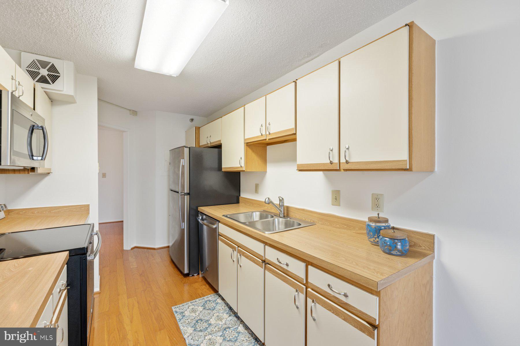 15107 Interlachen Drive, Unit 2801 Silver Spring, MD 20906 - Photo 14 of 50 a kitchen with a sink a stove and a refrigerator
