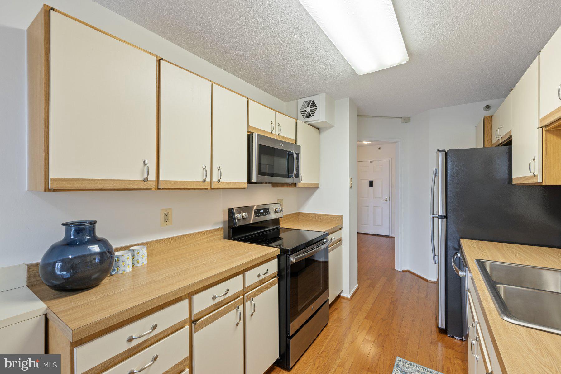 15107 Interlachen Drive, Unit 2801 Silver Spring, MD 20906 - Photo 15 of 50 a kitchen with stainless steel appliances granite countertop a stove a sink and a microwave