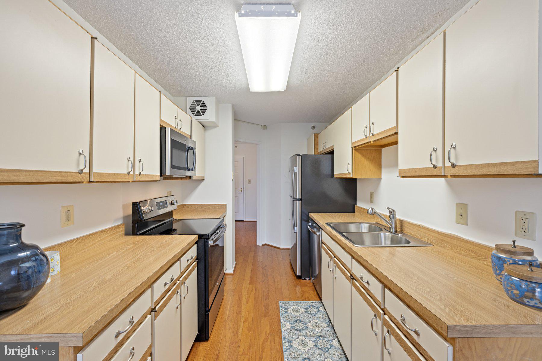 15107 Interlachen Drive, Unit 2801 Silver Spring, MD 20906 - Photo 16 of 50 a kitchen with stainless steel appliances granite countertop a sink a stove and a refrigerator