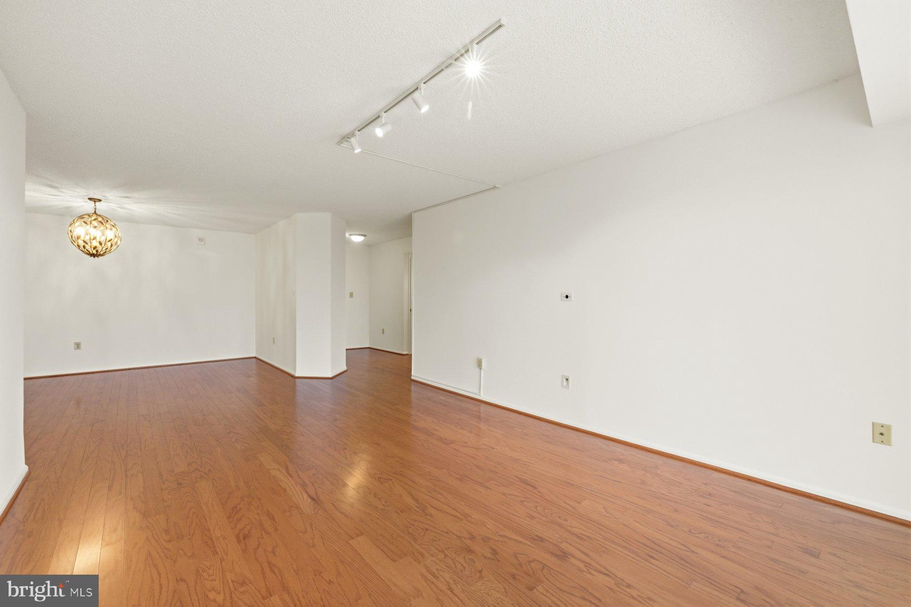 15107 Interlachen Drive, Unit 2801 Silver Spring, MD 20906 - Photo 5 of 50 an empty room with wooden floor and windows