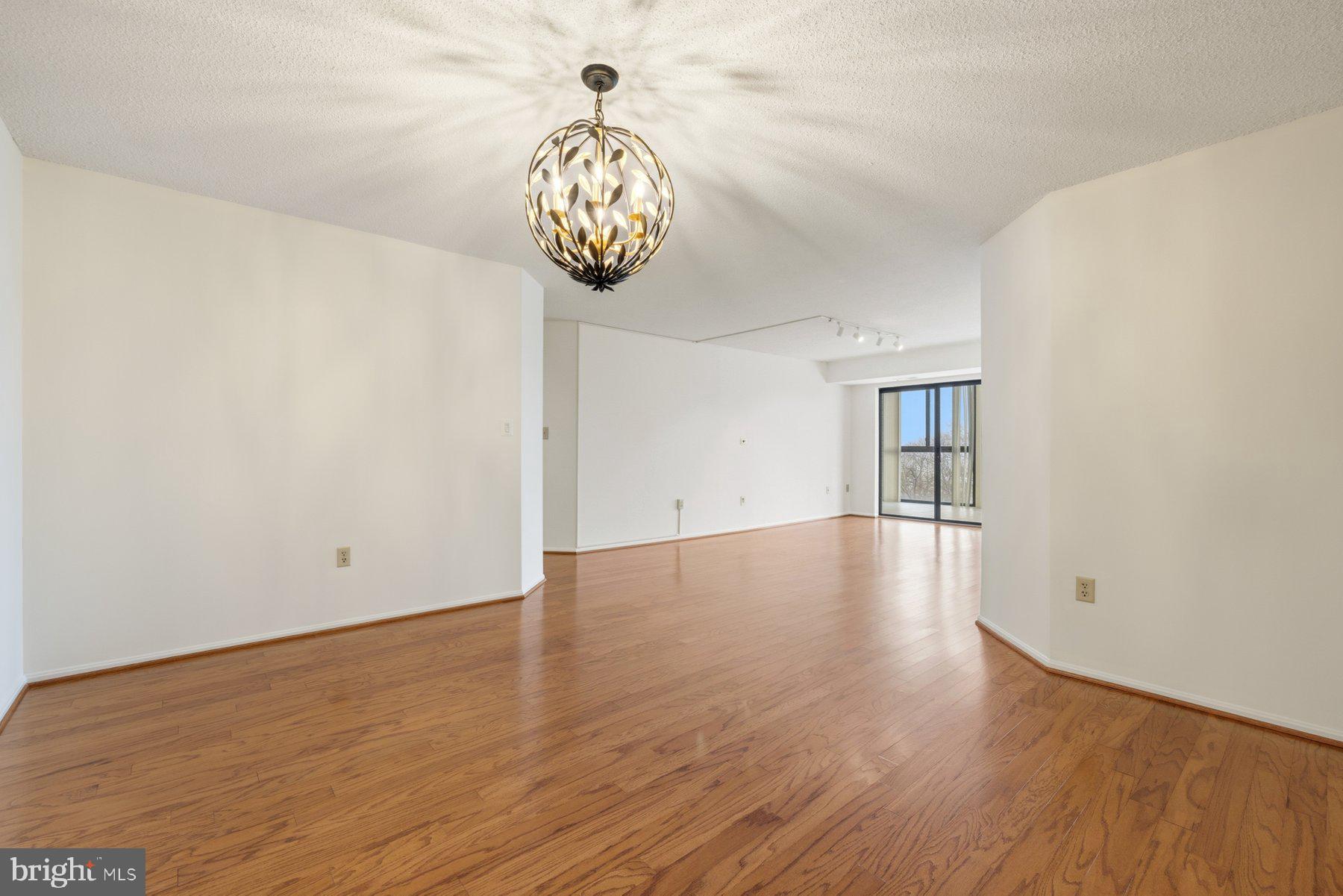 15107 Interlachen Drive, Unit 2801 Silver Spring, MD 20906 - Photo 9 of 50 a view of an empty room with wooden floor and windows