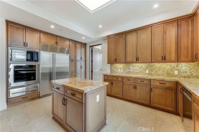 a kitchen with stainless steel appliances granite countertop a refrigerator and a stove top oven