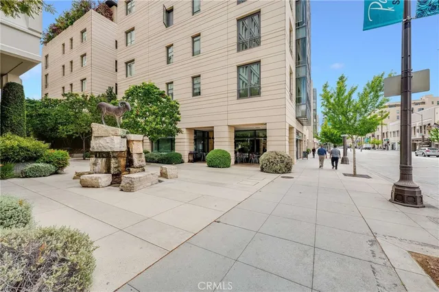 a view of a building with potted plants and a bench