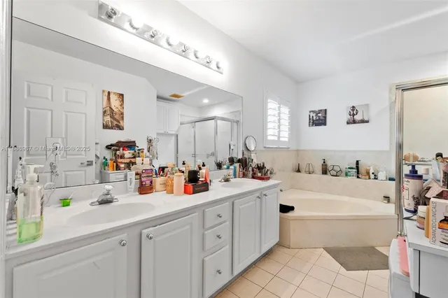 a bathroom with a double vanity sink mirror and bathtub