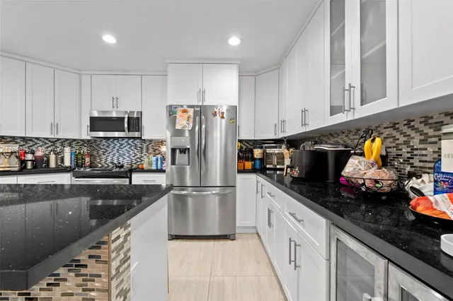 a kitchen with granite countertop a refrigerator and a sink