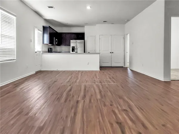a view of kitchen with wooden floor and electronic appliances