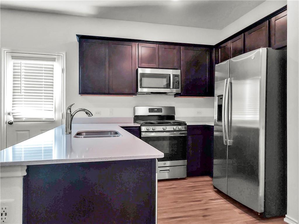 251 Geode Glen Maxwell, TX 78656 - Photo 2 of 16 a kitchen with a refrigerator sink and microwave