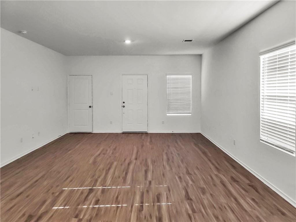251 Geode Glen Maxwell, TX 78656 - Photo 5 of 16 an empty room with wooden floor and windows