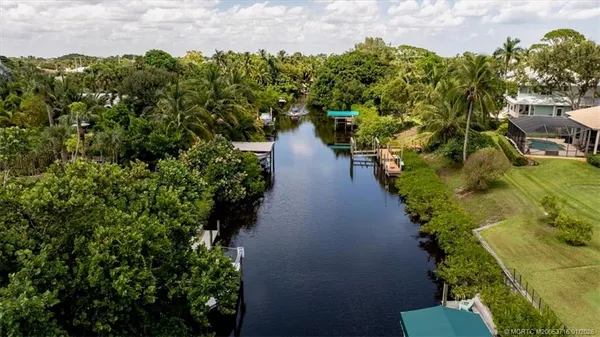 an aerial view of a house with a yard and lake view