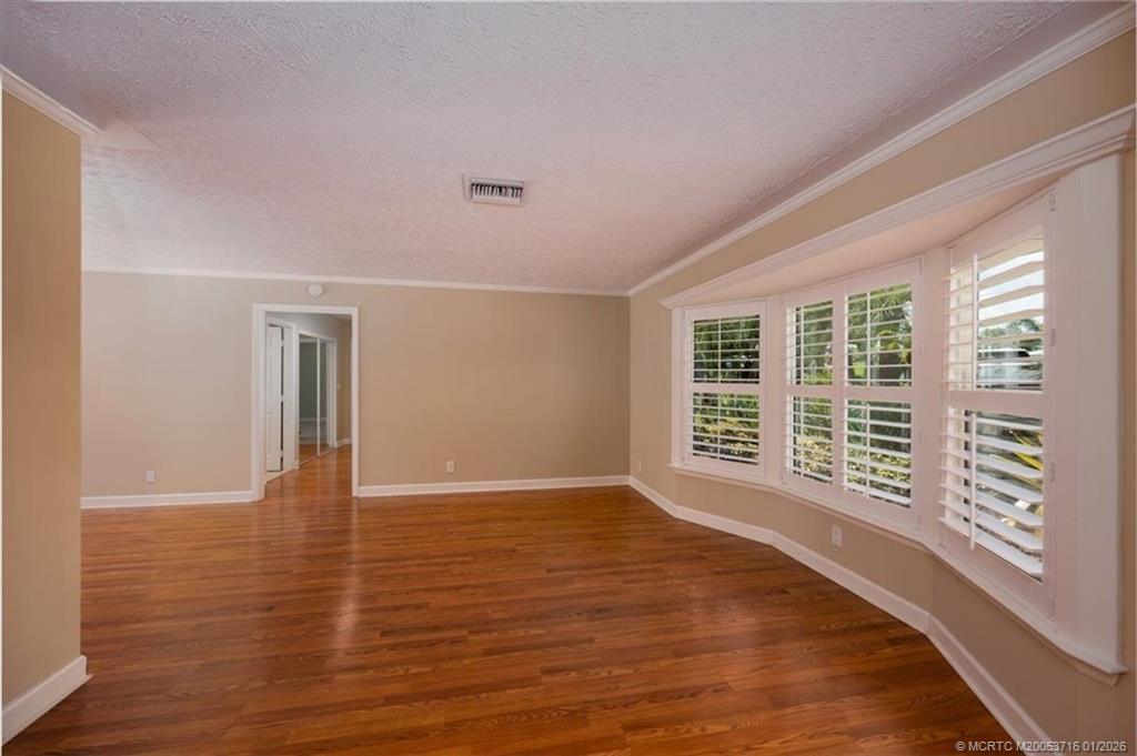 511 Krueger Parkway Stuart, FL 34996 - Photo 12 of 56 a view of an empty room with wooden floor and a window