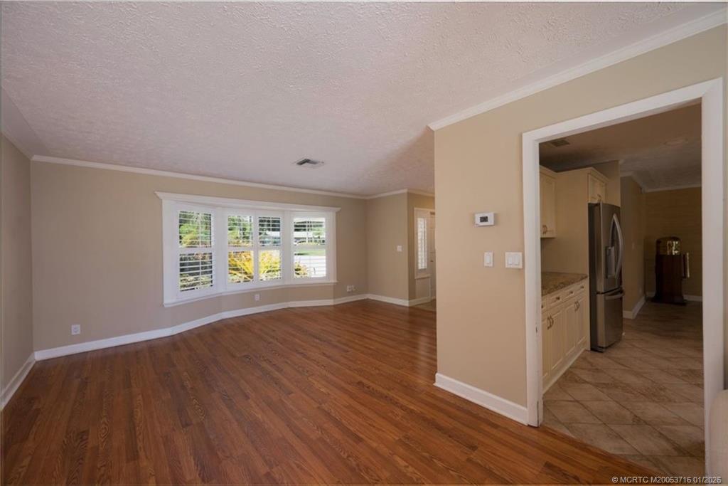 511 Krueger Parkway Stuart, FL 34996 - Photo 15 of 56 an empty room with wooden floor and windows