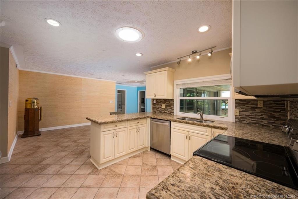 511 Krueger Parkway Stuart, FL 34996 - Photo 16 of 56 a kitchen with stainless steel appliances granite countertop a stove and a sink