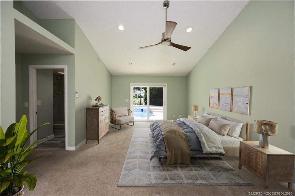 511 Krueger Parkway Stuart, FL 34996 - Photo 26 of 56 a spacious bedroom with a balcony a bed and a chandelier