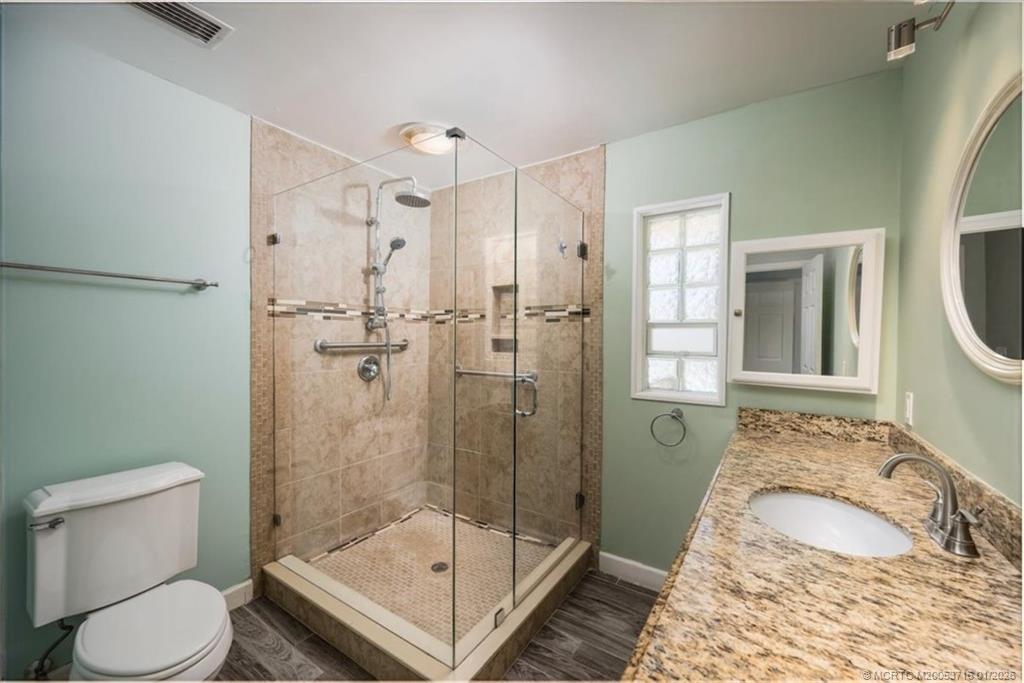 511 Krueger Parkway Stuart, FL 34996 - Photo 27 of 56 a bathroom with a granite countertop toilet sink and shower