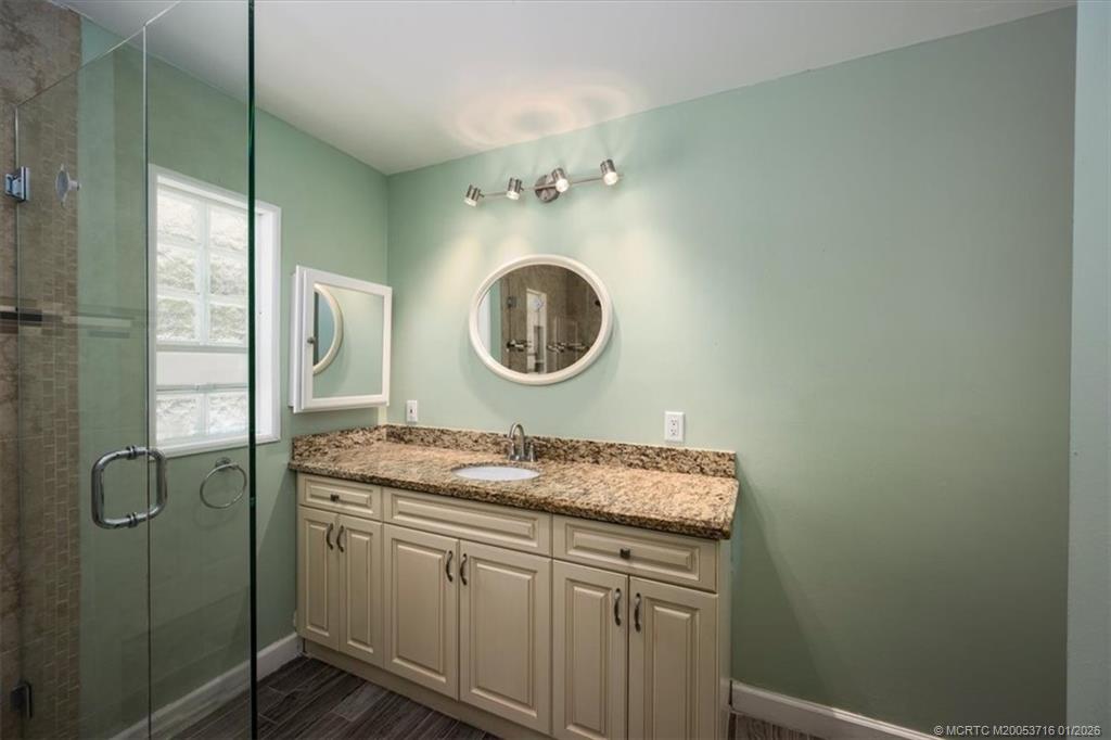 511 Krueger Parkway Stuart, FL 34996 - Photo 28 of 56 a bathroom with a granite countertop sink a mirror and a vanity