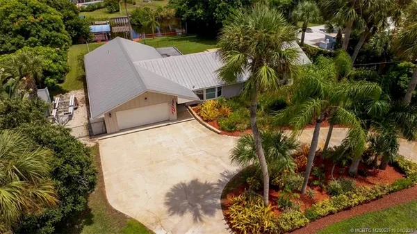 an aerial view of a house with a yard and lake view