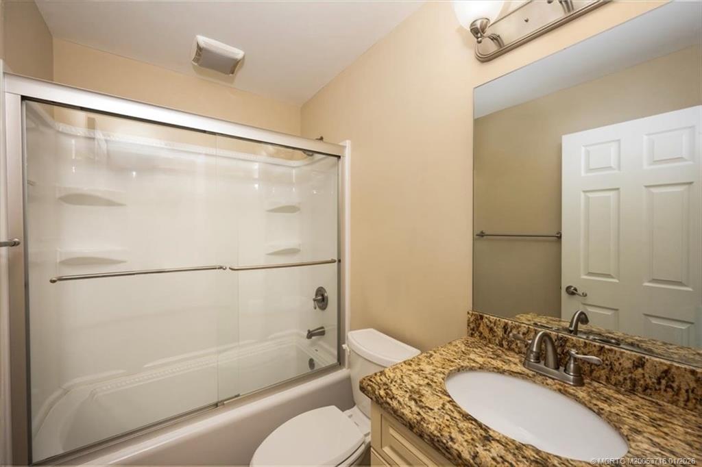 511 Krueger Parkway Stuart, FL 34996 - Photo 35 of 56 a bathroom with a granite countertop shower sink vanity mirror and toilet