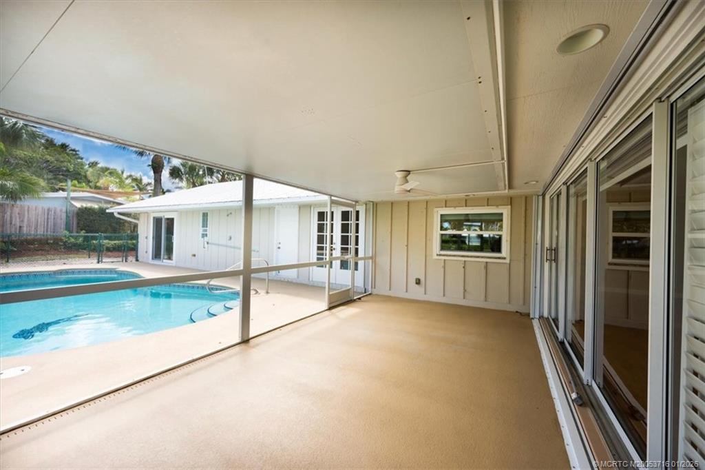 511 Krueger Parkway Stuart, FL 34996 - Photo 39 of 56 an empty room with floor to ceiling windows and a table