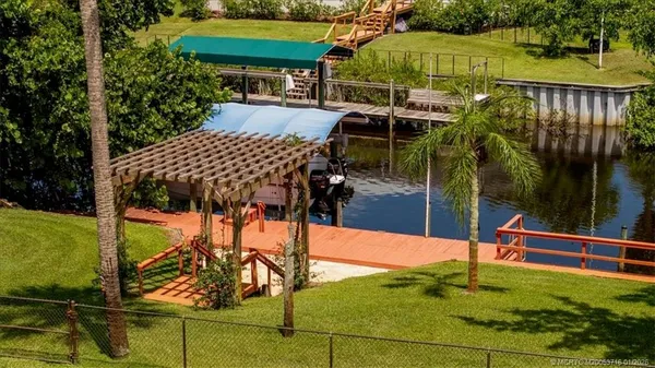 an aerial view of a house with swimming pool and lake view