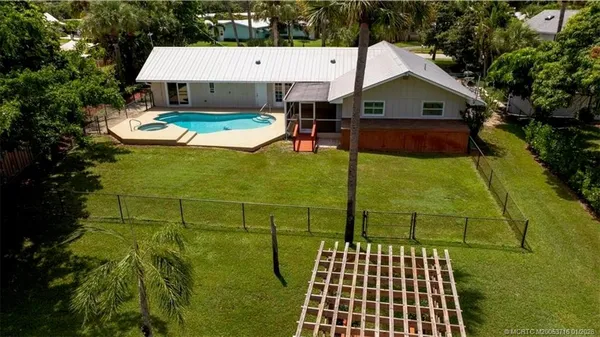 an aerial view of a house with swimming pool and deck