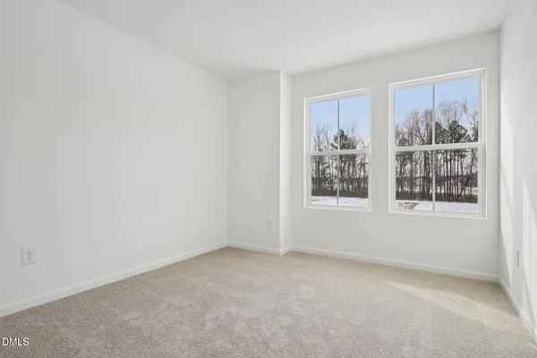a view of a big room with windows and chandelier fan