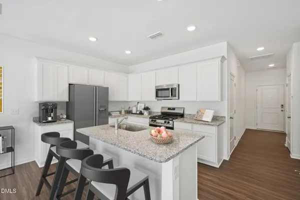 a kitchen with a dining table chairs refrigerator and cabinets