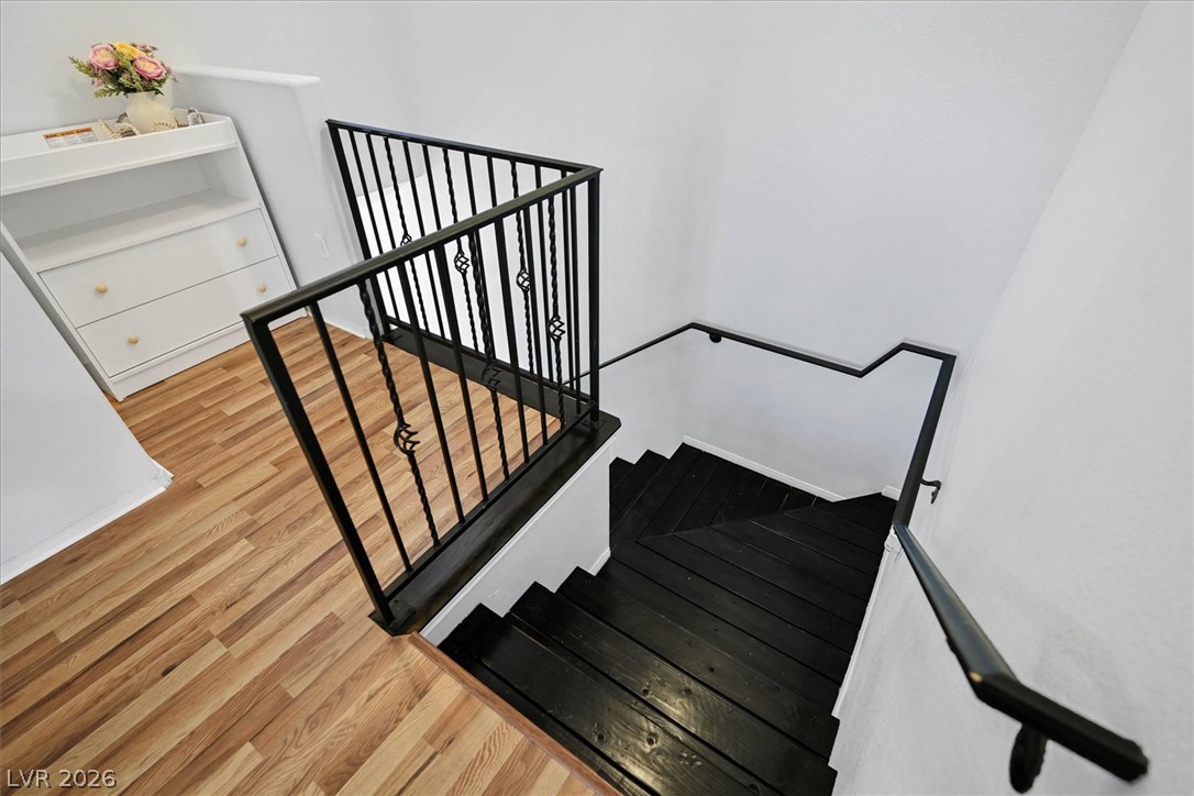 8555 West Russell Road, Unit 2069 Las Vegas, NV 89113 - Photo 5 of 27 Modern black wrought iron railings guide descent to lower levels, complementing the sleek hardwood flooring.