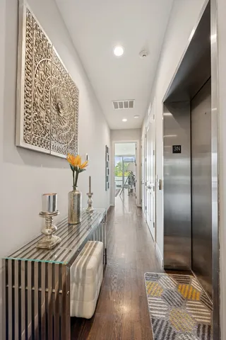 a hallway with a view of living room with wooden floor
