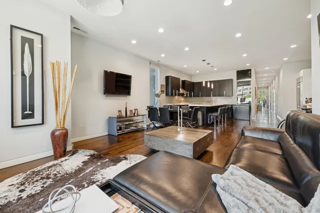 a living room with stainless steel appliances furniture and a flat screen tv