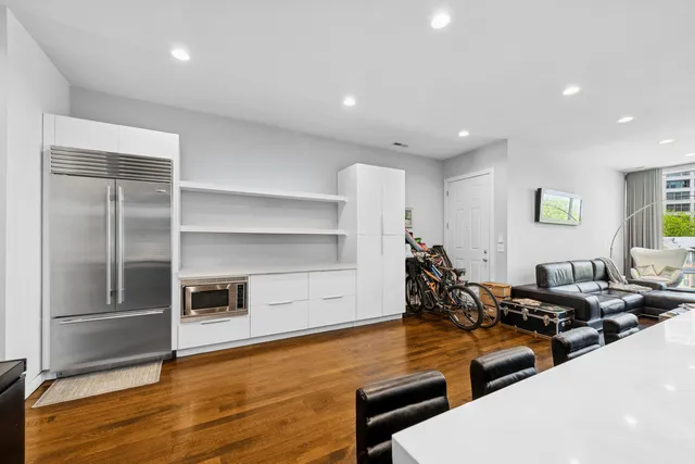 a living room with furniture wooden floor and kitchen view