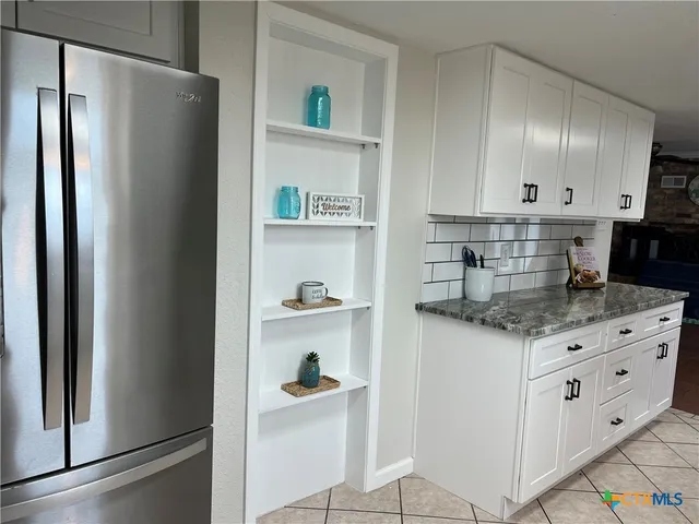 a kitchen with granite countertop white cabinets and a stainless steel appliances