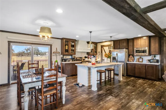 a kitchen with kitchen island granite countertop a sink counter and chairs