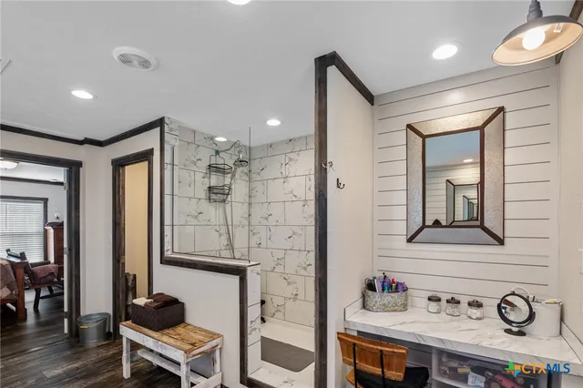 a spacious bathroom with a tub a sink and a large mirror next to a window