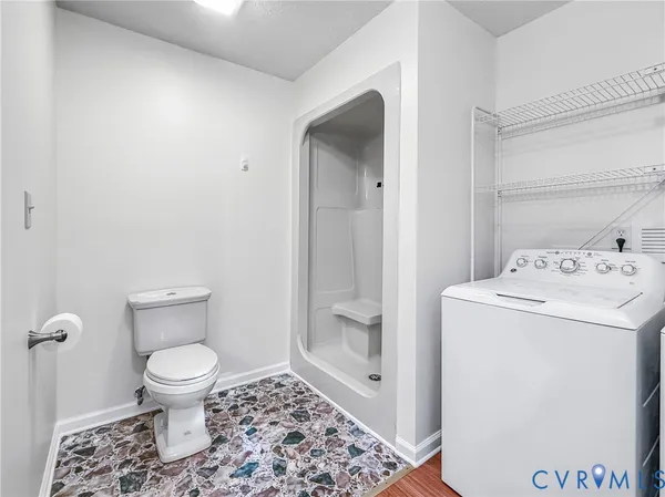 a bathroom with a granite countertop toilet and a sink