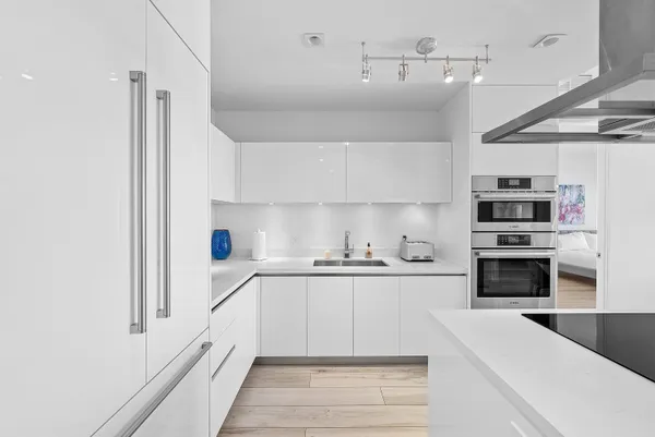 a kitchen with a sink a counter top space stainless steel appliances and cabinets