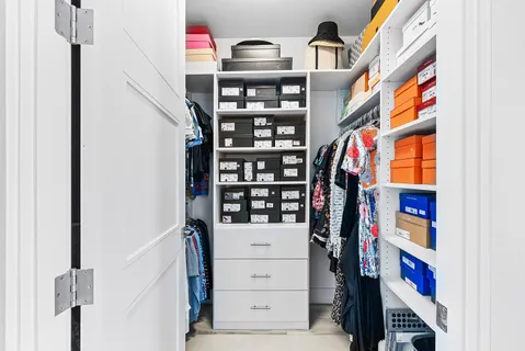 a view of walk in closet with clothes and shoes