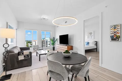 a living room with furniture a flat screen tv and a table