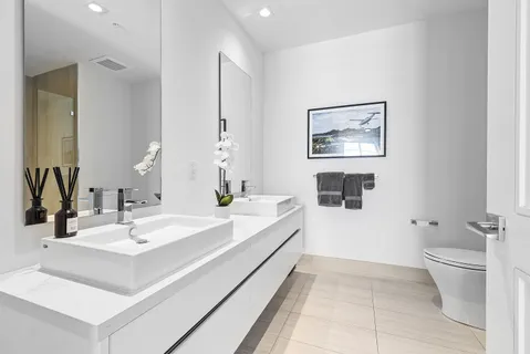 a bathroom with a double vanity sink toilet and a mirror