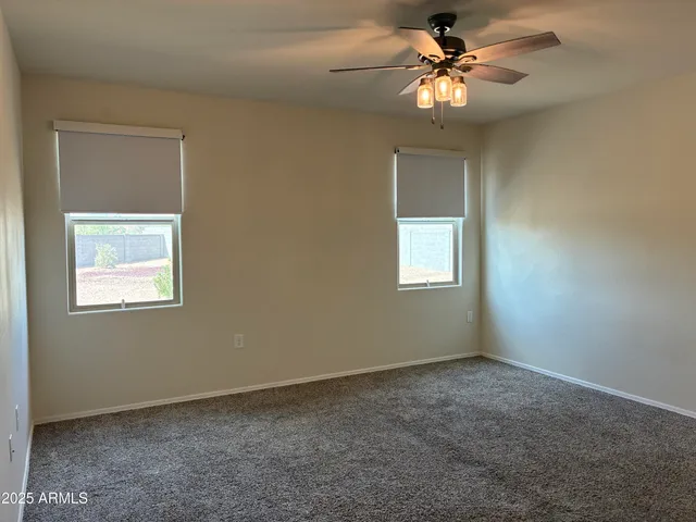 an empty room with a window and a fan