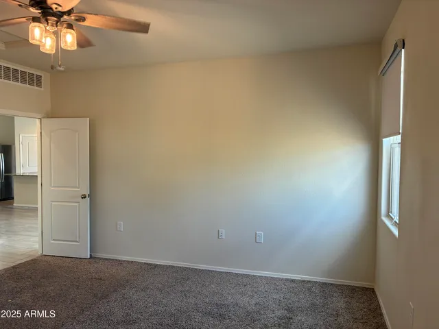 an empty room with a window and a ceiling fan