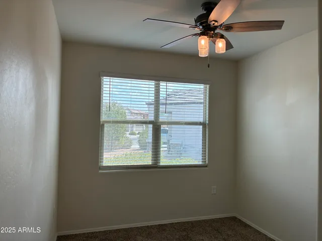 an empty room with a window and a fan
