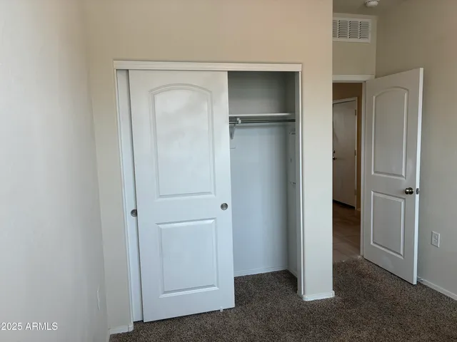 a view of an empty room with closet area